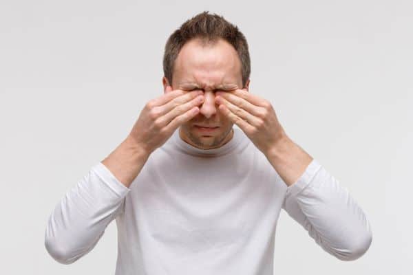 Homem maduro esfregando os olhos. Síndrome do Olho Seco, frequente durante a primavera. 