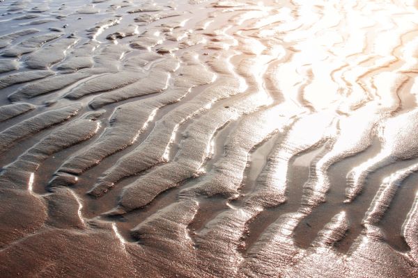 Superfície arenosa da praia com excesso de claridade, em razão do sol, pode ser uma das causas da fotossensibilidade.