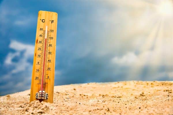 Termômetro enterrado na areia da praia sugere o calor extremo pelo qual o Brasil vem passando neste verão de 2024, provocado pelo fenômeno El Niño.