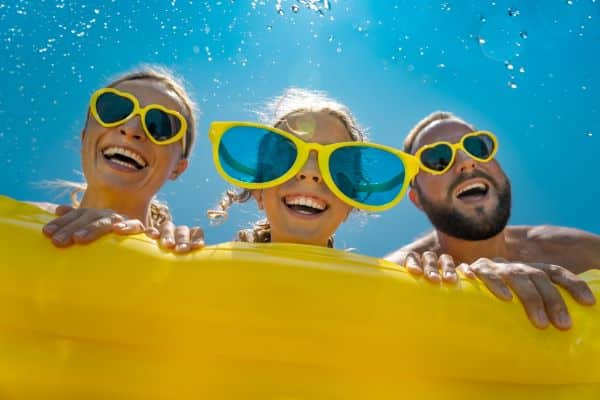 Família diverte-se nas férias de verão protegida por óculos de sol.