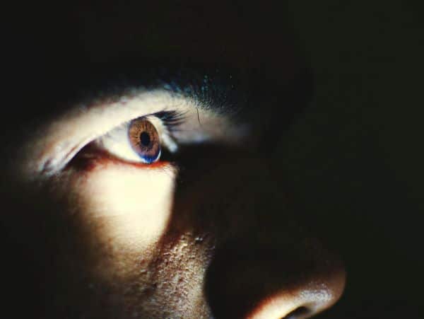 Close do olho de um homem que apresenta dificuldade de visão noturna em razão de retinopatia pigmentar. 
Conceito de retinopatias.