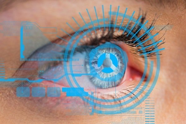 Close no olho azul de uma mulher no qual há um holograma.