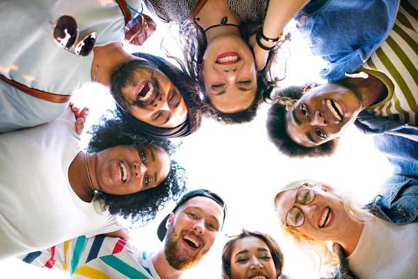 Grupo de amigos divertindo-se ao ar livre e pousando para foto.